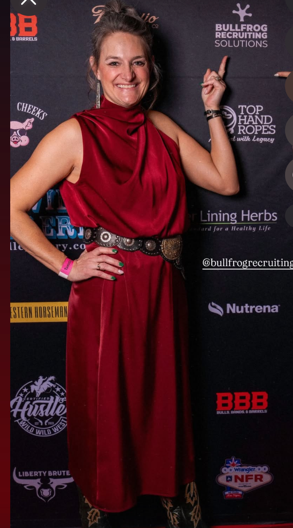 Heidi Foy, founder of Bullfrog Recruiting Solutions stands in front of a step and repeat with the BFR logo outside of the venue of the NFR Watch Party in Las Vegas.